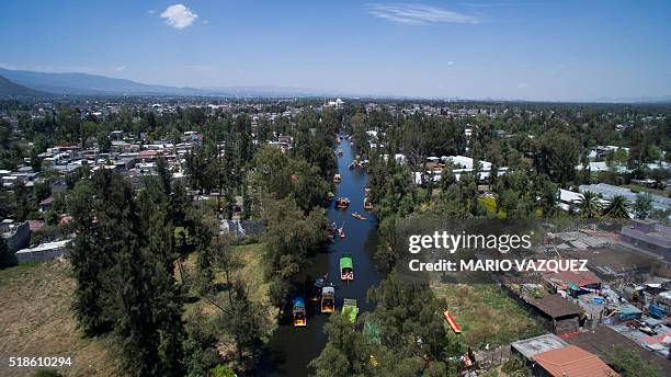 Aerial view taken with a drone of "trajineras" -traditional flat-bottomed river boat- at Xochimilco natural reserve in Mexico City on April 1, 2016....