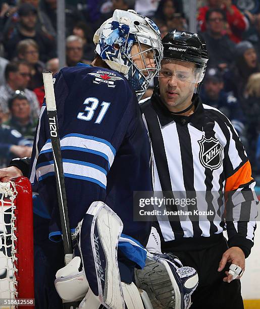 Goaltender Ondrej Pavelec of the Winnipeg Jets chats with referee Kyle Rehman during a first period stoppage in play against the Chicago Blackhawks...