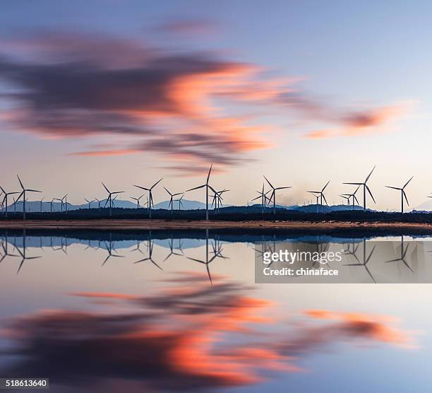 torri elettriche e turbine eoliche al tramonto - vento foto e immagini stock