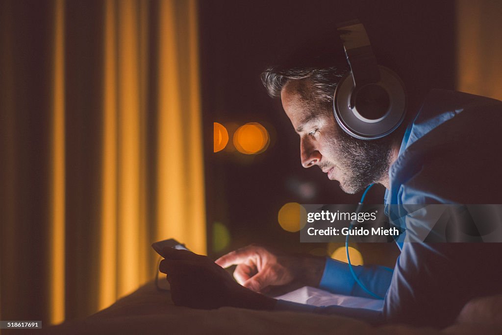 Man using tablet pc in evening.