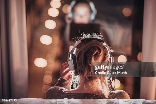 woman using tablet pc in evening. - listening stockfoto's en -beelden