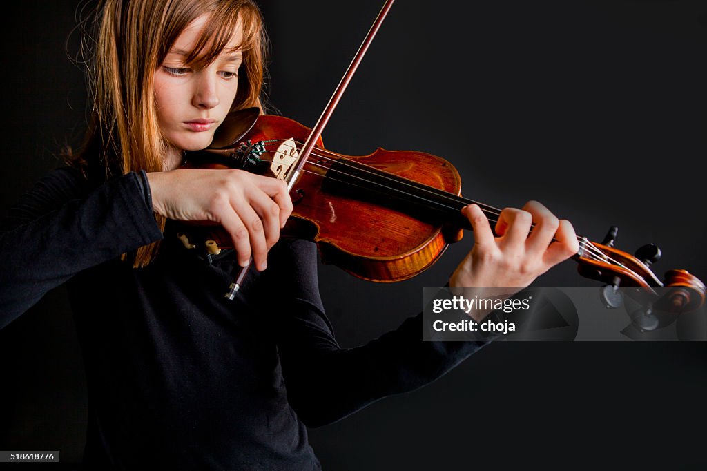 Portrait of young violinist with old and valuable violin..