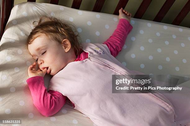 baby girl sleeping in crib - cot stock pictures, royalty-free photos & images