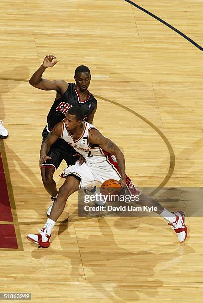 Dajuan Wagner of the Cleveland Cavaliers drives around Ben Gordon of the Chicago Bulls during the game on November 27, 2004 at Gund Arena in...