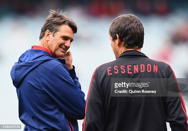 Paul Roos the coach of the Demons talks to Mark Harvey the assistant coach of the Bombers during the round two AFL match between the Essendon Bombers...