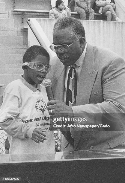 Man and athlete speaking to the crowd during the Special Olympics, Maryland, 1995.