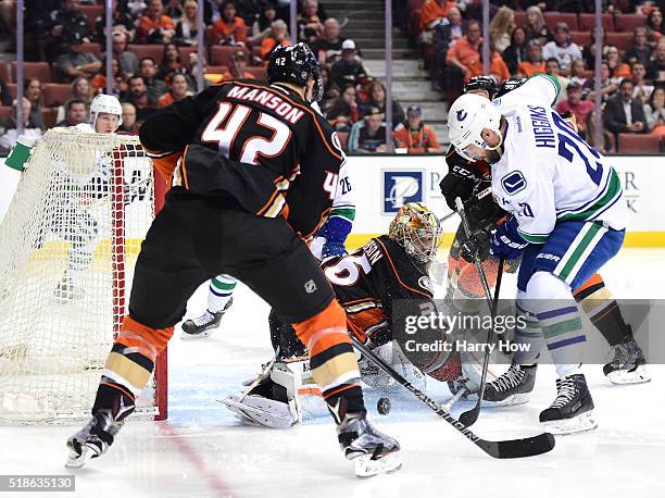 John Gibson of the Anaheim Ducks makes a save on Chris Higgins of the Vancouver Canucks as Josh Manson looks to clear a rebound during the second...