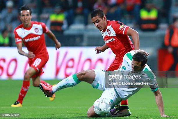 Alexis Vega of Toluca struggles for the ball with Carlos Izquierdoz of Santos Laguna during the 12th round match between Toluca and Santos Laguna as...