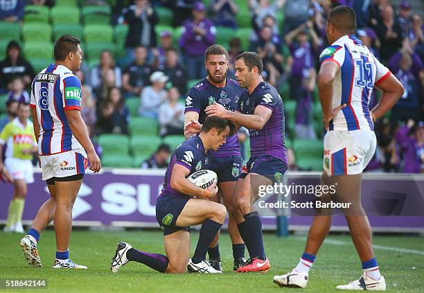 Cooper Cronk of the Storm is congratulated by Cameron Smith and his teammates after scoring his second try during the round five NRL match between...