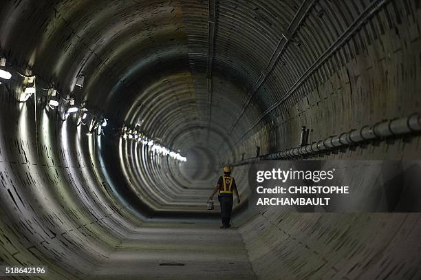 This picture taken on March 8, 2016 shows a worker walking in a tunnel under construction along the current extension of the Metropolitan Rapid...