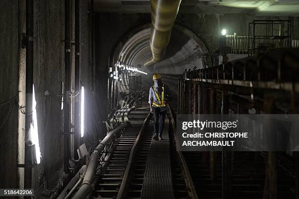 This picture taken on March 11, 2016 shows a worker walking in a tunnel under construction along the current extension of the Metropolitan Rapid...