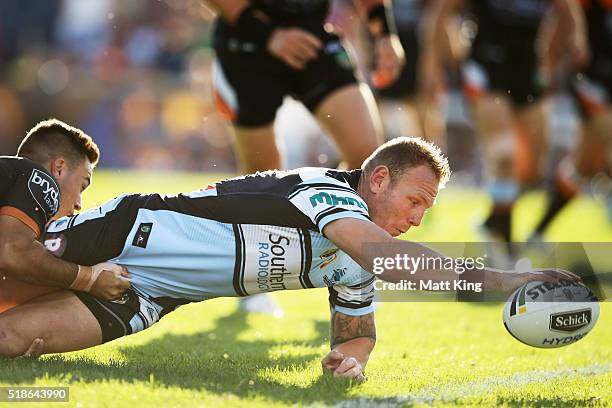 Luke Lewis of the Sharks reaches out to score a try during the round five NRL match between the Wests Tigers and the Cronulla Sharks at Campbelltown...