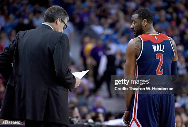 Head coach Randy Wittman of the Washington Wizards talks with player John Wall during a break in the action against the Sacramento Kings Kings during...