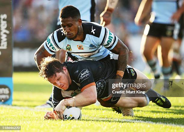 Chris Lawrence of the Tigers beats Ben Barba of the Sharks to score a try during the round five NRL match between the Wests Tigers and the Cronulla...