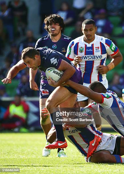 Cameron Smith of the Storm is tackled during the round five NRL match between the Melbourne Storm and the Newcastle Knights at AAMI Park on April 2,...