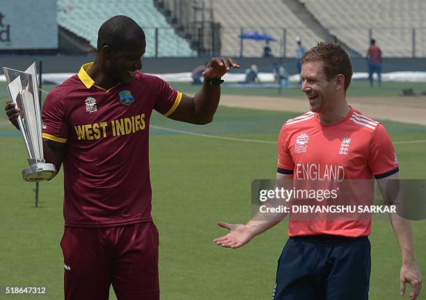 England's cricket team captain Eoin Morgan and West Indies captain Darren Sammy pose with the World T20 tournament trophy at the Eden Gardens cricket...