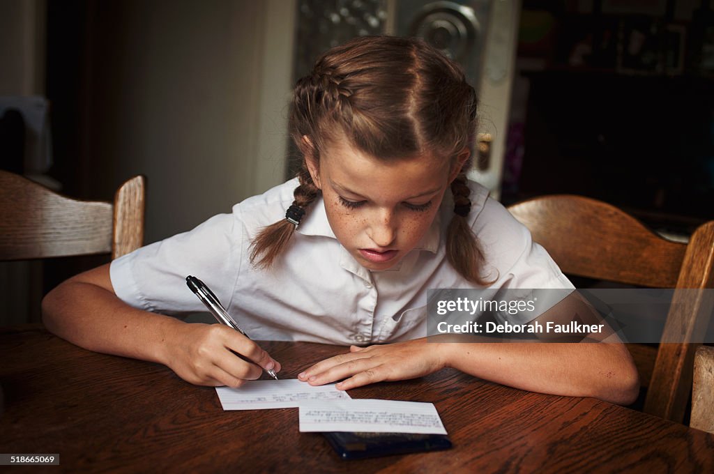 Girl writing at a table