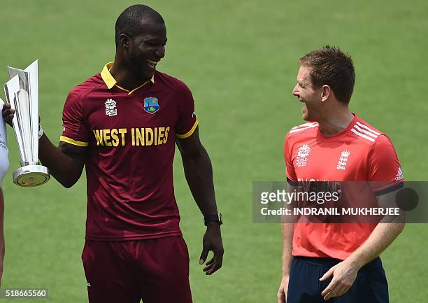 England's cricket team captain Eoin Morgan and West Indies captain Darren Sammy pose with the World T20 tournament trophy at the Eden Gardens cricket...
