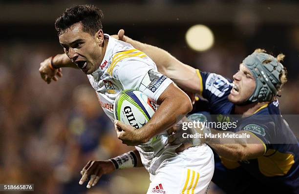 James Lowe of the Chiefs evades the tackle of David Pocock of the Brumbies to score a try during the round six Super Rugby match between the Brumbies...