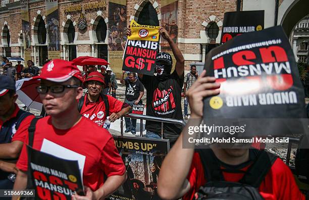 Protesters hold up posters during a rally against Prime Minister Najib Razak and GST at Independent Square on April 2, 2016 in Kuala Lumpur,...