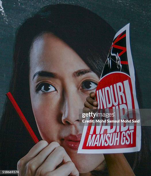 Protester holds up a placard during a rally against Prime Minister Najib Razak and GST at Independent Square on April 2, 2016 in Kuala Lumpur,...