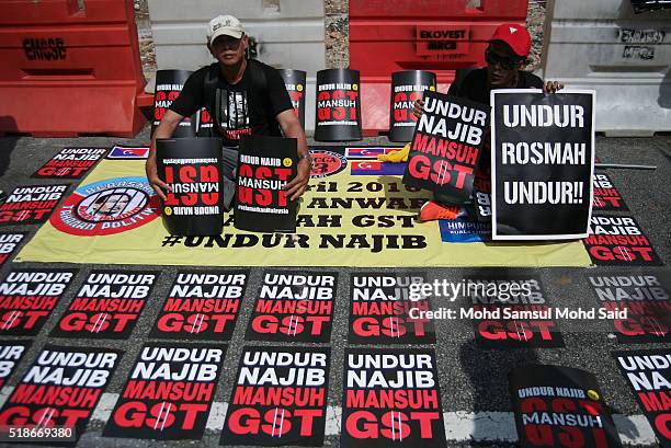 Protester shows posters during a rally against Prime Minister Najib Razak and GST at Independent Square on April 2, 2016 in Kuala Lumpur, Malaysia....