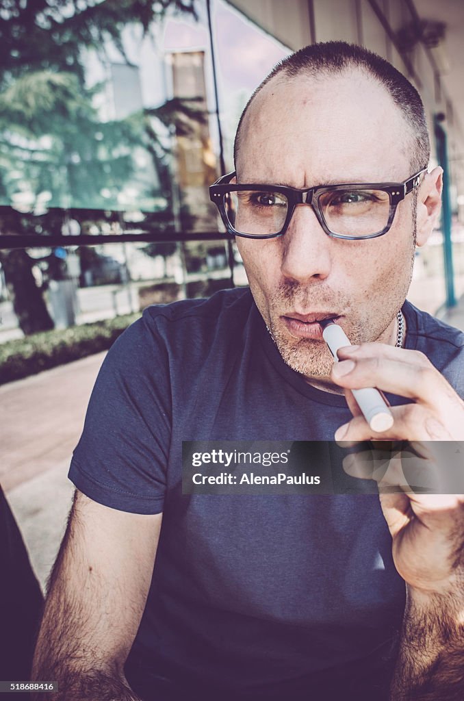 Man vaping outdoors, people using electronic cigarettes in daily life