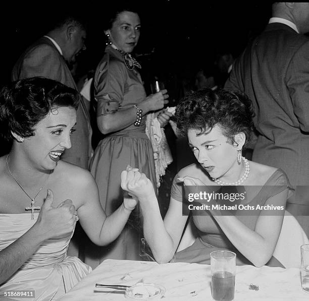 Rita Moreno puts her fists up toward Katy Jurado as they attend a party at Ciro's in Los Angeles,CA.