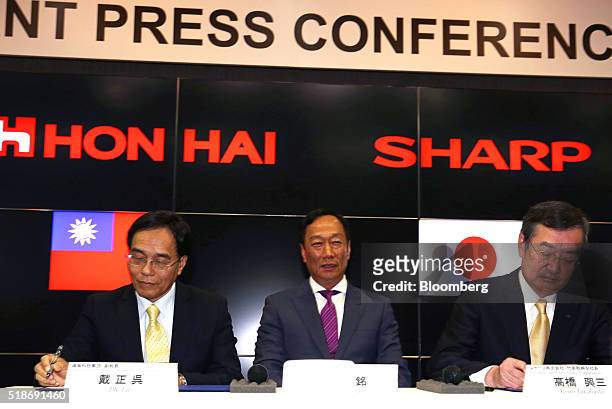 Billionaire Terry Gou, chairman of Foxconn Technology Group, center, looks on as Tai Jeng-wu, vice president of Foxconn Technology Group, left, and...