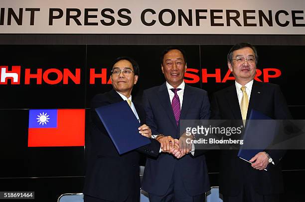 Tai Jeng-wu, vice president of Foxconn Technology Group, left, shakes hands with Billionaire Terry Gou, chairman of Foxconn Technology Group, center,...