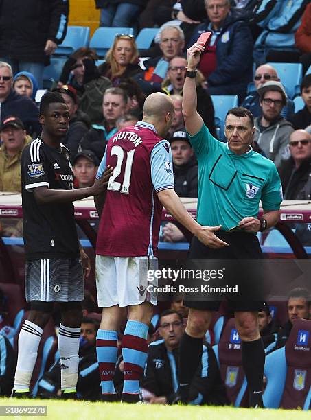 Alan Hutton of Aston Villa is shown a red card by referee Neil Swarbrick during the Barclays Premier League match between Aston Villa and Chelsea at...