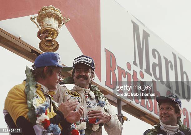 Clay Regazzoni of Switzerland driver of the Albilad-Saudi Racing Team Williams FW07 Cosworth V8 celebrates with second placed Rene Arnoux and third...