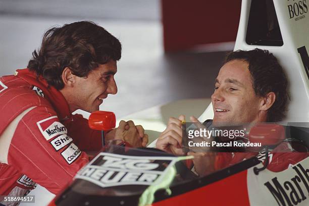 Ayrton Senna, driver of the McLaren-Honda MP4/5B shares a funny joke with team mate Gerhard Berger during pre season testing 1st February 1990 at the...