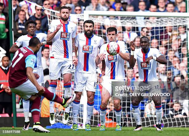 The Crystal Palace wall prepares to jump to block West Ham United's French midfielder Dimitri Payet's freekick but cannot prevent him scoring their...
