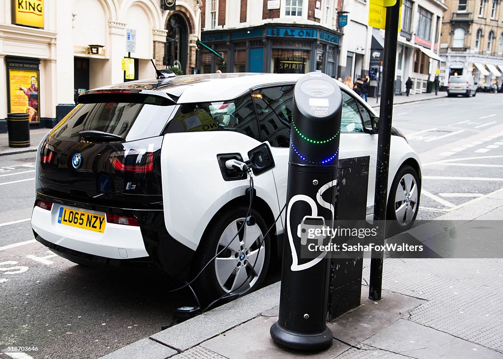 Electric car being recharged at a meter in London, UK