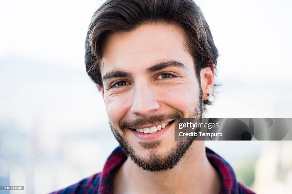 Young man with beard looking at camera.