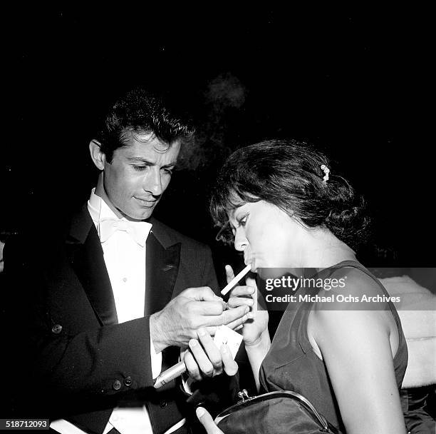 George Chakiris lights Rita Moreno cigarette at an event in Los Angeles,CA.