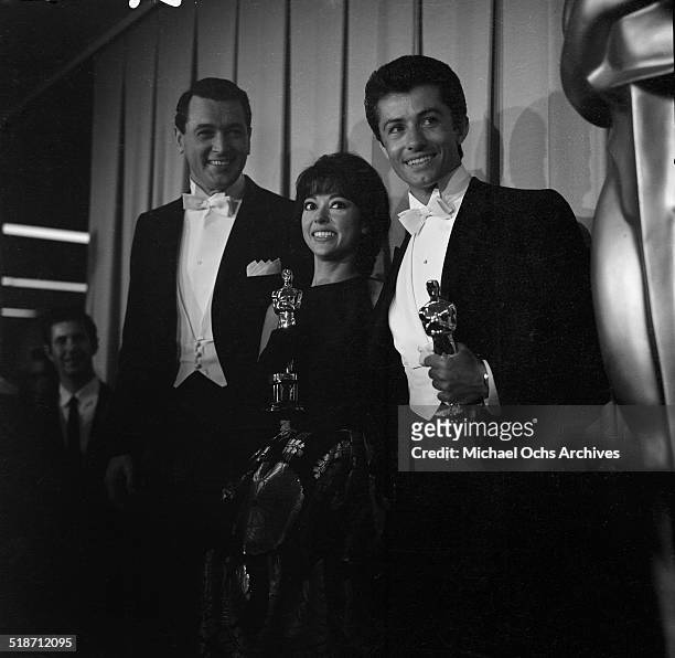 Rock Hudson stands with Rita Moreno and George Chakiris with their Oscar during the Academy Awards after winning for "West Side Story" in Los...