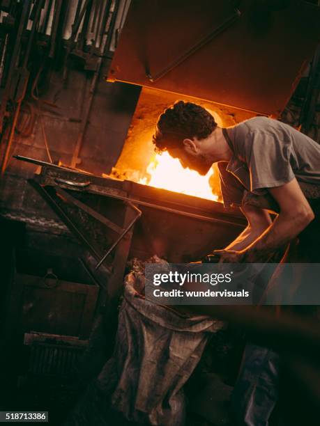 artigiano al lavoro forno in fabbro ferraio del negozio - fucina foto e immagini stock