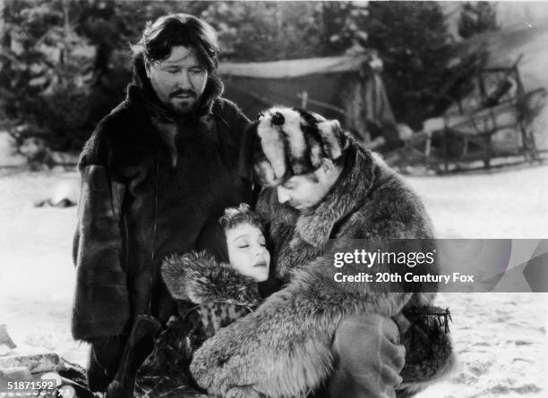 American actor Clark Gable embraces the reclined form of American actress Loretta Young as American actor Jack Oakie looks on in this still from the...