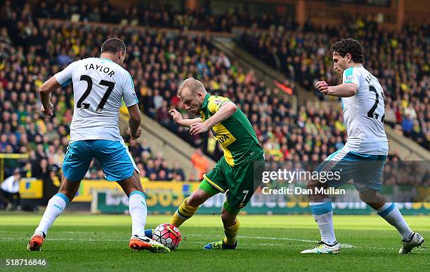 Steven Naismith of Norwich City competes for the ball against Steven Taylor and Daryl Janmaat of Newcastle United during the Barclays Premier League...