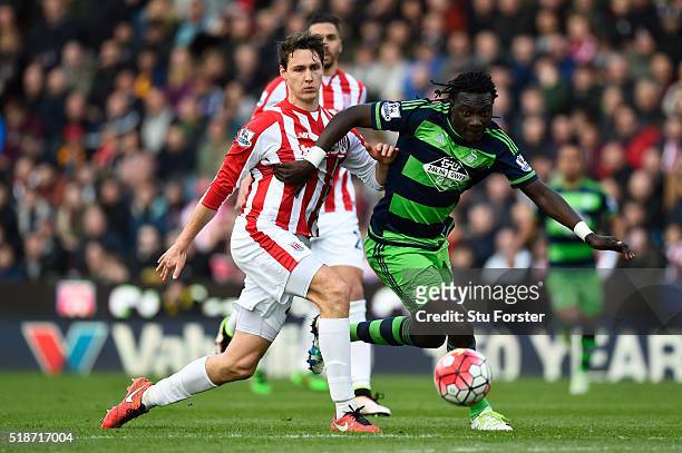 Bafetimbi Gomis of Swansea City and Philipp Wollscheid of Stoke City compete for the ball during the Barclays Premier League match between Sstoke...
