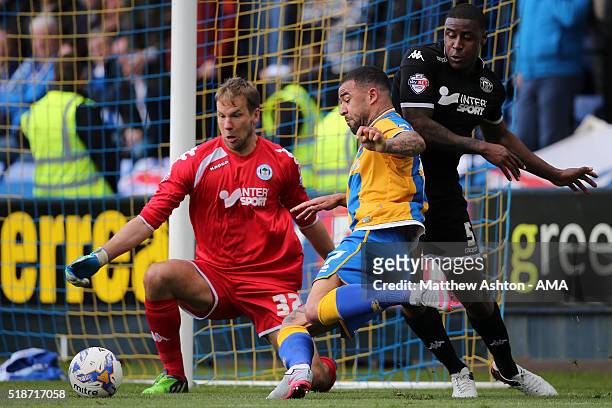 Jussi Jaaskelainen of Wigan Athletic tries to block an effort from Kyle Vassell of Shrewsbury Town with Donervon Daniels of Wigan Athletic defending...