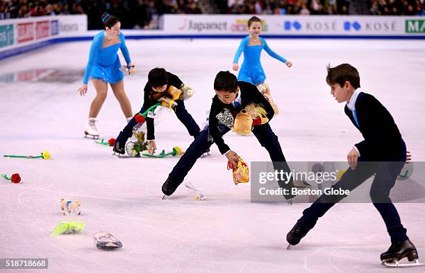 Children skate and pick up flowers and stuffed animals after Yuzuru Hanyu, not pictured, skated during the Mens Free Skate Program competition of the...