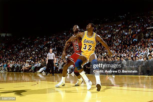 Magic Johnson of the Los Angeles Lakers battles for position with Michael Jordan of the Chicago Bulls during the NBA game at the Forum in Los...