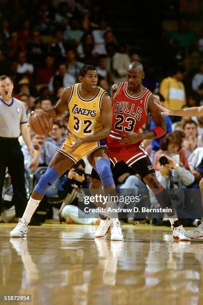 Magic Johnson of the Los Angeles Lakers looks to make a play while Michael Jordan of the Chicago Bulls defends during Game Five of the 1991 NBA...