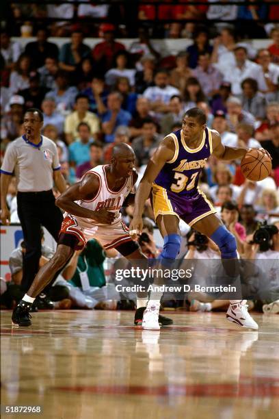 Magic Johnson of the Los Angeles Lakers looks to make a play against Michael Jordan of the Chicago Bulls during the NBA game in Chicago, Illinois....