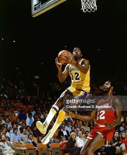 Magic Johnson of the Los Angeles Lakers goes for a layup against the Houston Rockets during the NBA game at the Forum in Los Angeles, California....