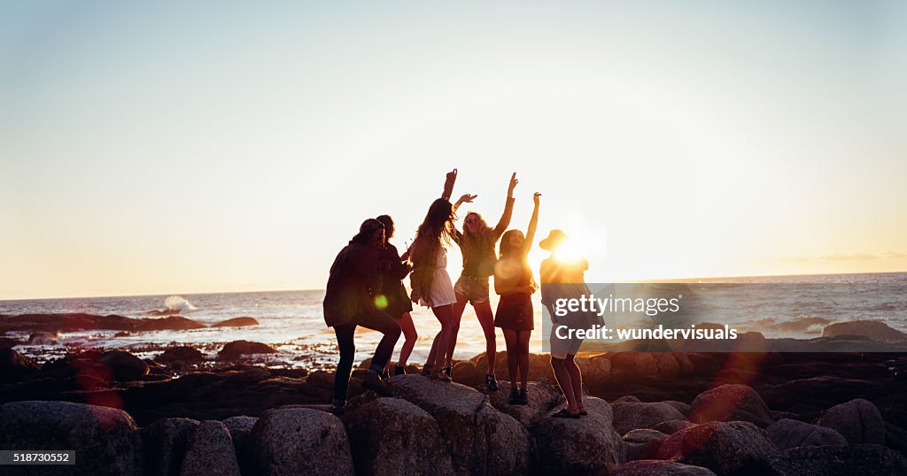 Hipster unterhaltsame Freunde, Tanzen am Strand bei Sonnenuntergang