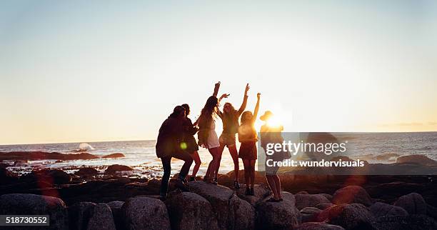 hipster unterhaltsame freunde, tanzen am strand bei sonnenuntergang - us girls on the beach stock-fotos und bilder